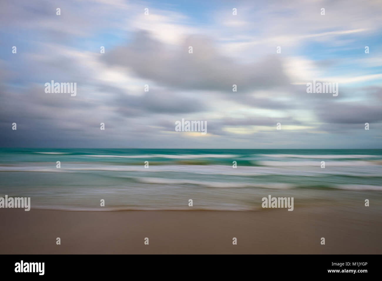 Abstract defocalizzazione motion blur sullo sfondo delle onde che si infrangono su una spiaggia tropicale con le tempeste all'orizzonte Foto Stock