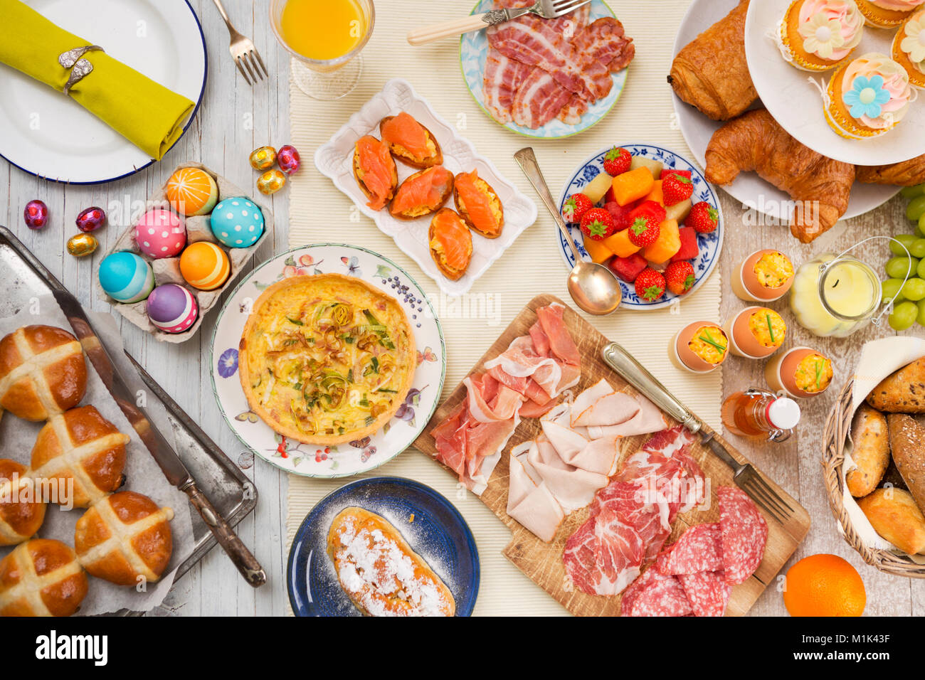 La colazione o il brunch tabella riempita con tutti i tipi di deliziosa gastronomia pronta per un pasto di Pasqua. Foto Stock