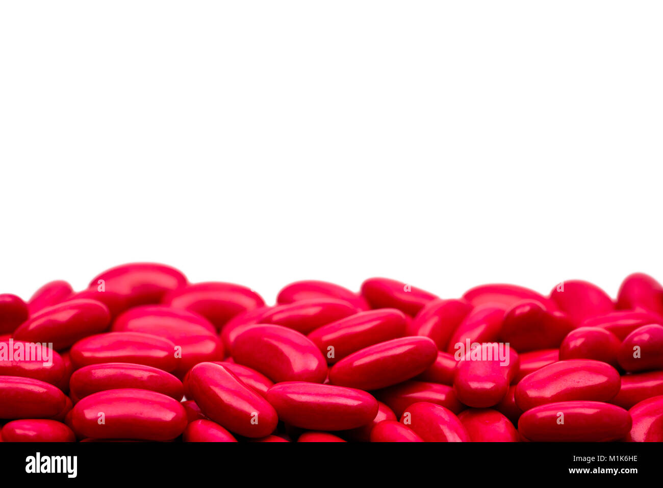 Macro shot dettaglio del rene rosso zucchero forma compressa rivestita pillole su sfondo bianco con copia spazio per il testo Foto Stock