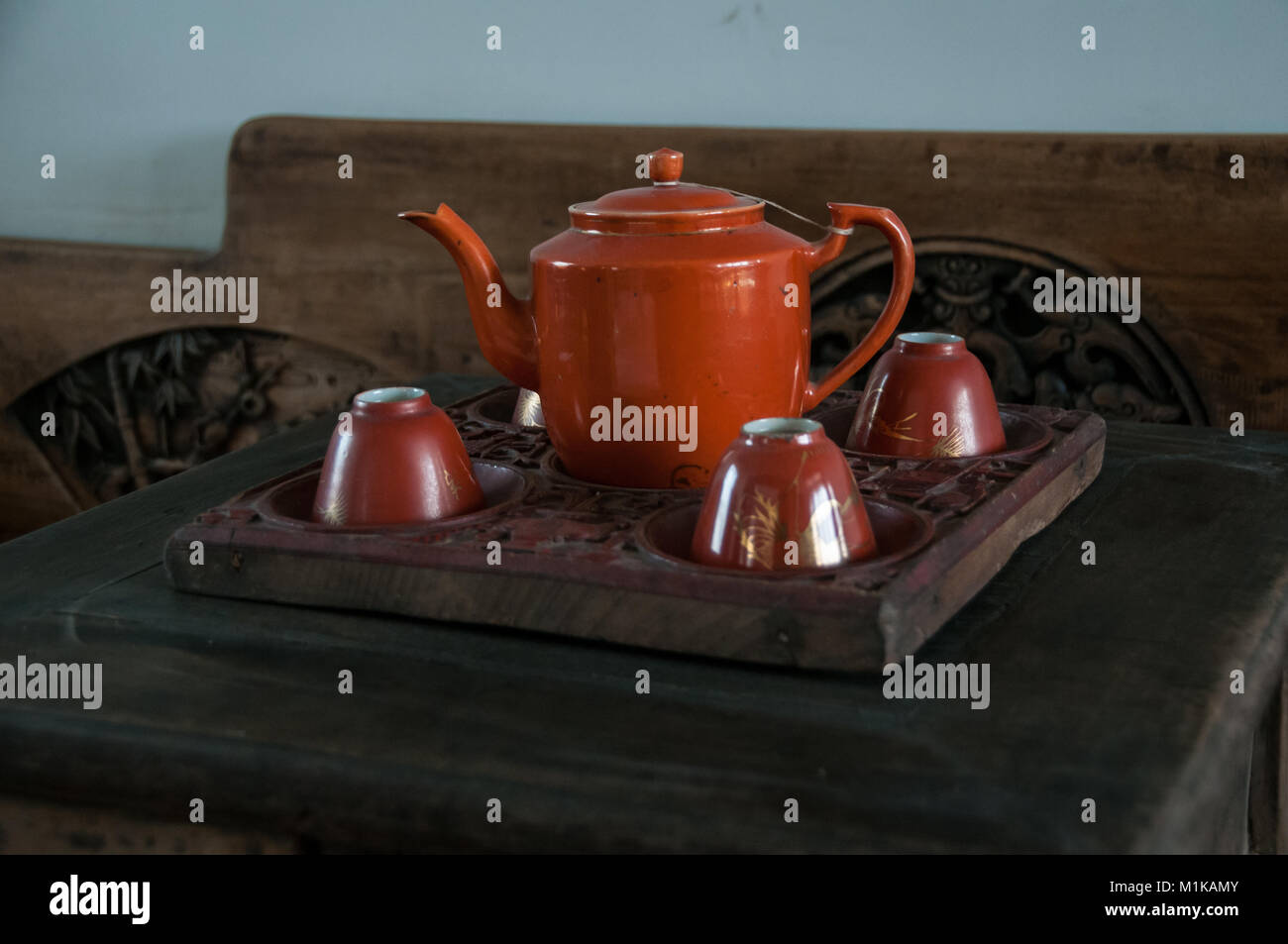 Un tè di porcellana impostato su un vassoio in legno con intarsi su un letto in legno in background. Parte della collezione privata di Wu Jianguo un ex Guardie rosse. Foto Stock