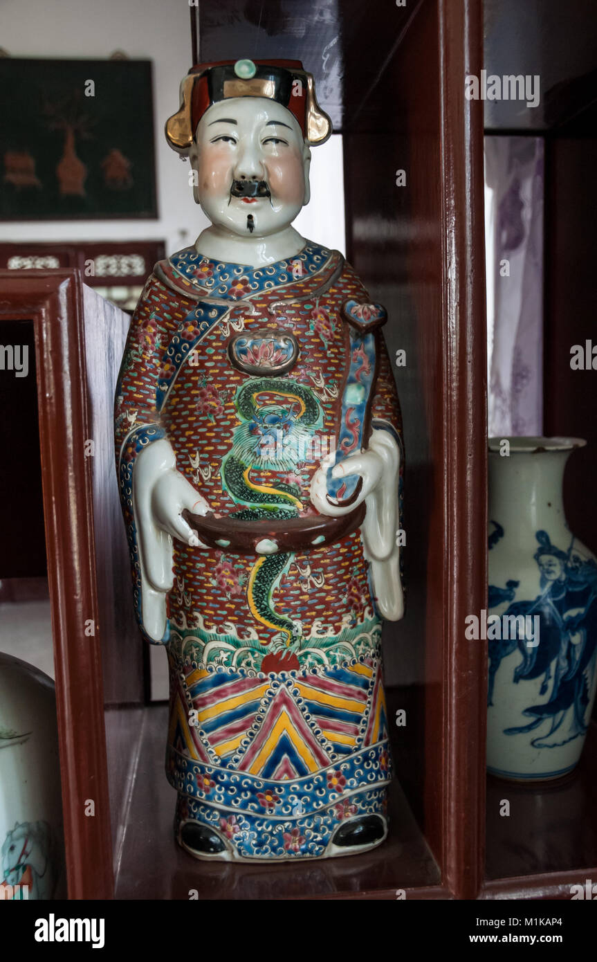 Un display in legno armadio visualizzando una ceramica figurina di un funzionario di governo. Parte di Wu Jianguo la collezione di antiche ceramiche cinesi. Trova Foto Stock