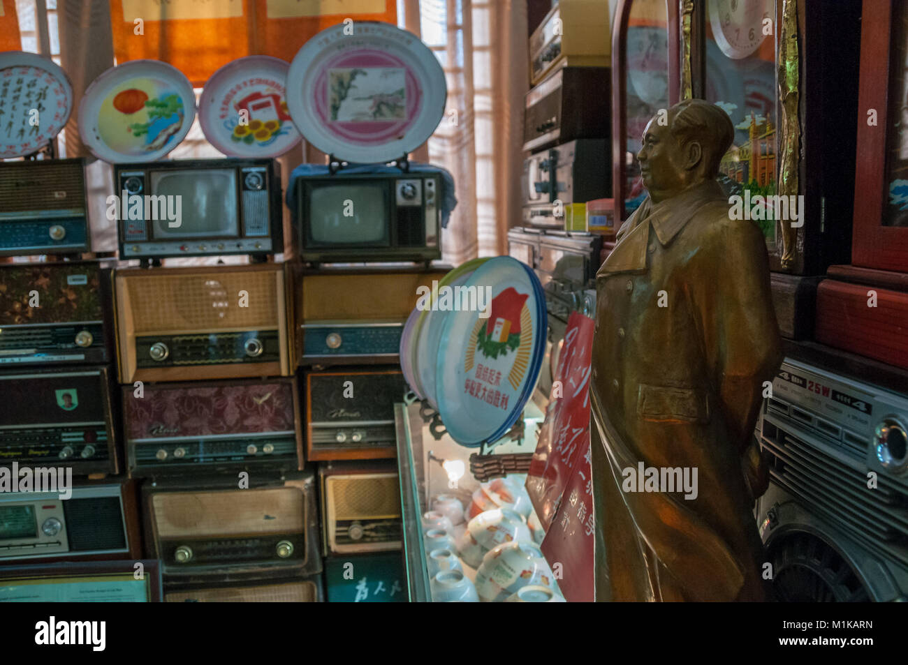 Una statua del presidente Mao con una raccolta dei primi apparecchi radio, televisori e altri articoli a partire già dai primi anni della Cina comunista. Parte di Jiangu Wu Foto Stock