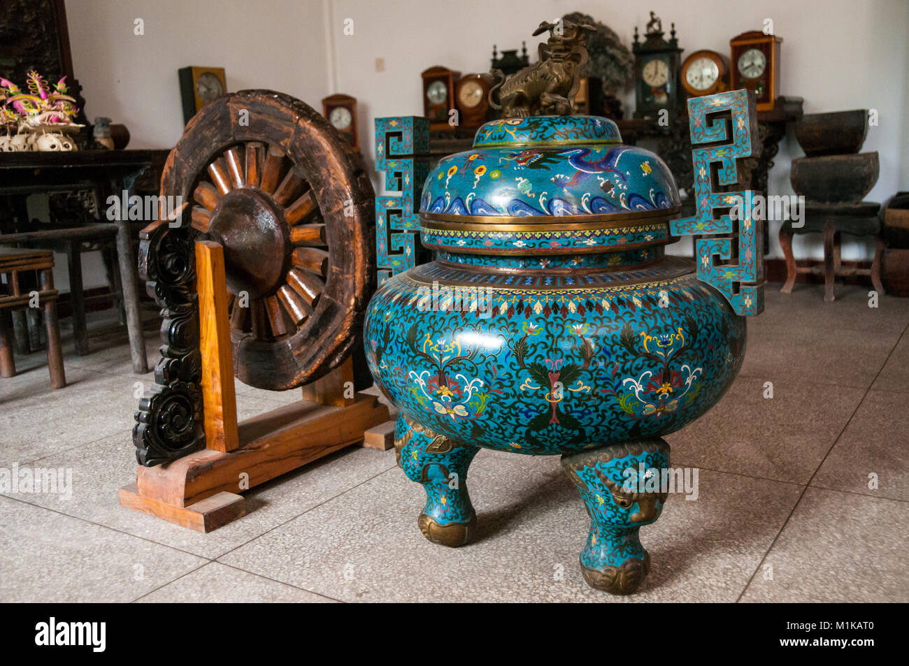 Un URN e ruota in legno con vecchi orologi in background. Parte di Wu Jianguo della collezione di antichi si trova nella zona rurale di Xi'an. Foto Stock