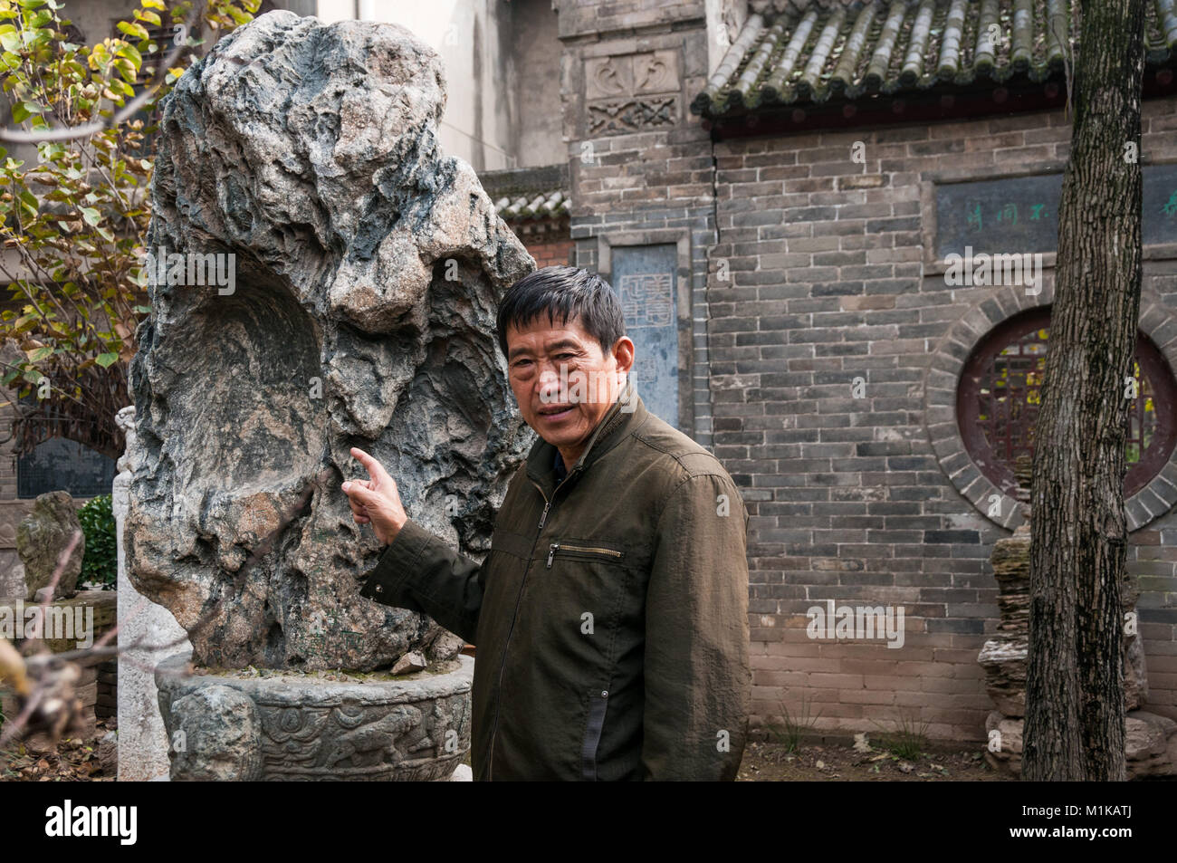 Wu Jianguo con un vecchio decorativi in pietra parte della sua collezione in parte rurale di Xi'an. Foto Stock