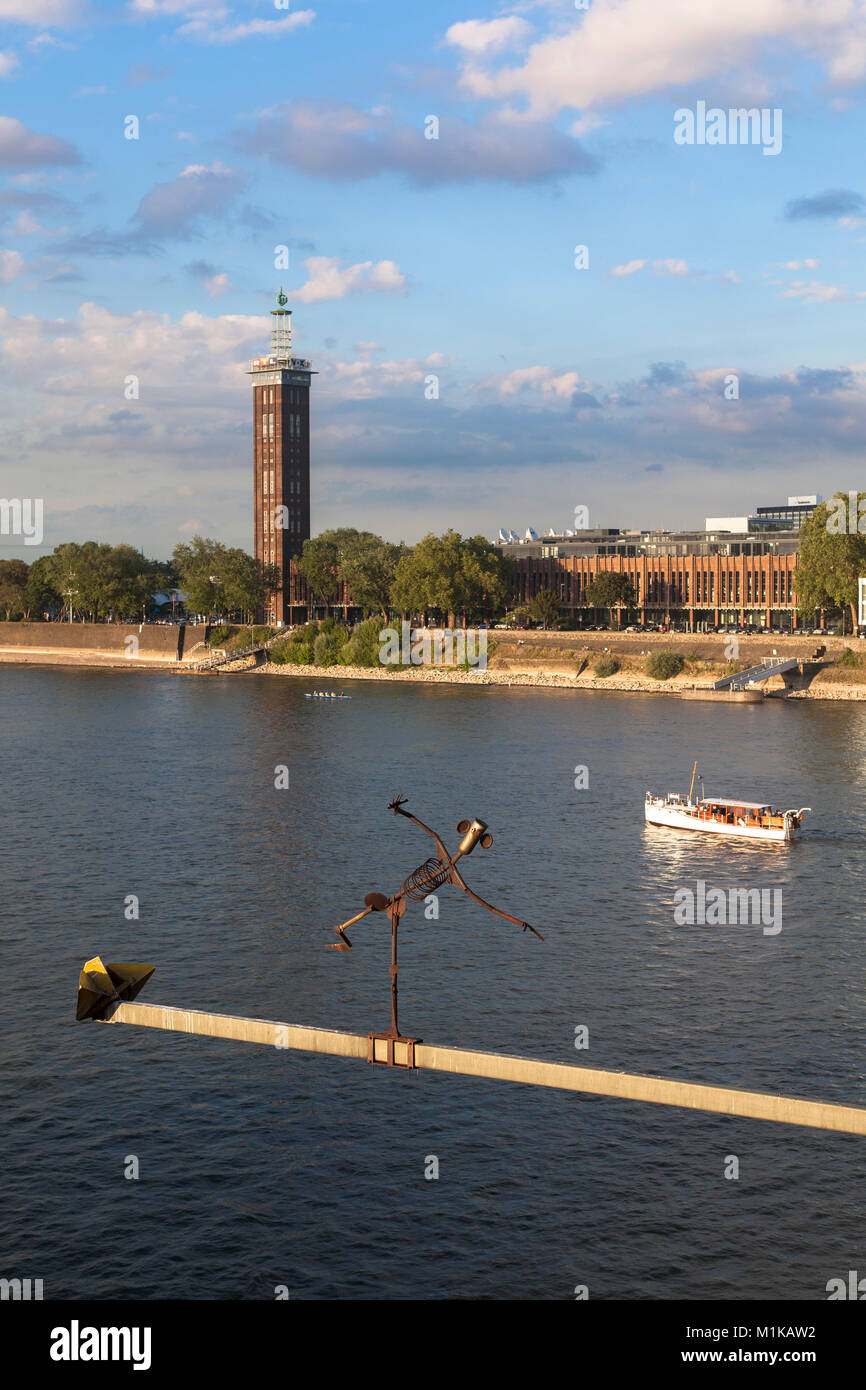 Germania, Colonia, vista sul fiume Reno fino alla vecchia torre dell'ex centro espositivo nel quartiere Deutz, scultura Brueckenmaennchen su un Foto Stock