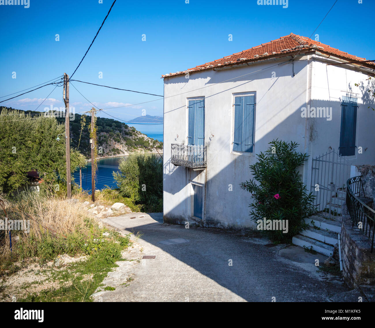 Dipinto di bianco di villa con persiane blu nel piccolo villaggio di pescatori di Kioni in greco isole Ionie Foto Stock