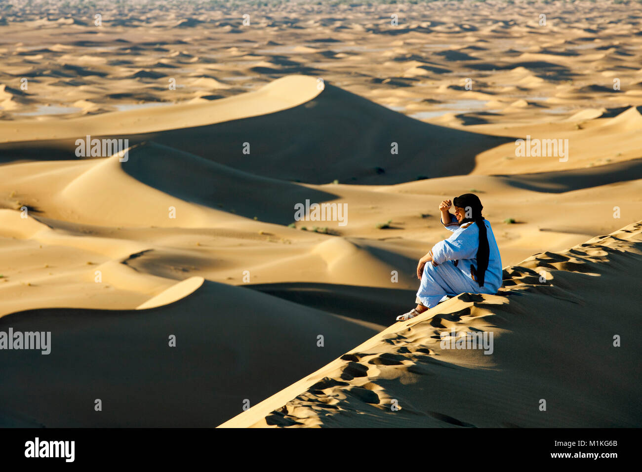 Il Marocco, Mhamid, Erg Chigaga dune di sabbia. Deserto del Sahara. Local Berber uomo sulla duna di sabbia. Foto Stock