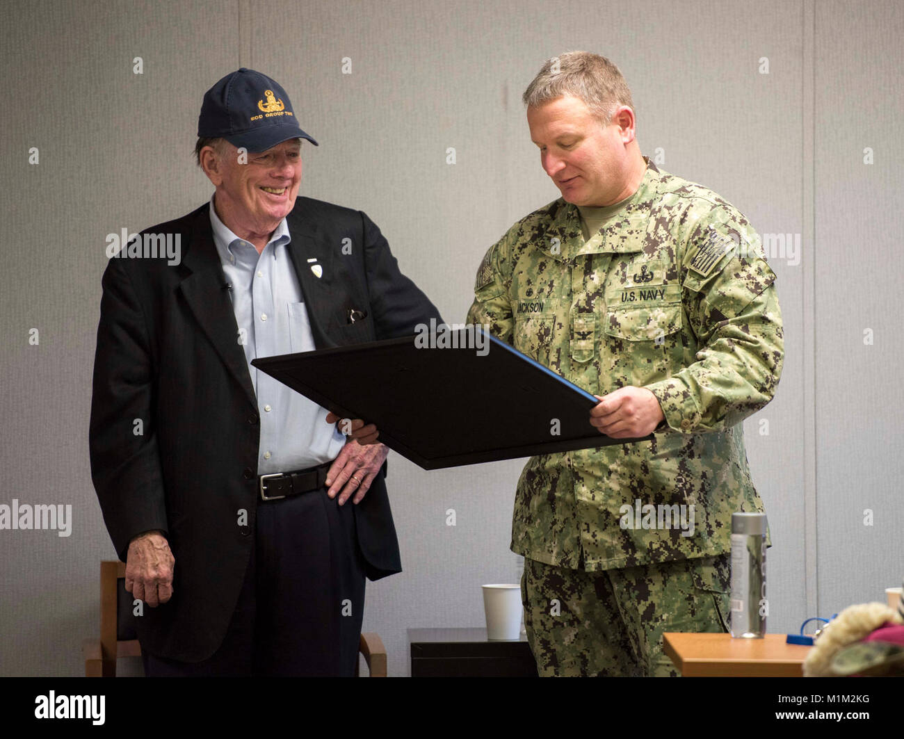 VIRGINIA BEACH, Va. (GEN. 26, 2018) Joseph Galloway, ex corrispondente di combattimento e co-autore del premiato libro "Ci sono stati i soldati una volta…e giovani", riceve un onorario certificato disposaleer da Capt. Josh Jackson, comandante dell'eliminazione degli ordigni esplosivi gruppo (EODGRU) 2, durante una discussione di leadership con il comando triadi e potenziali i comandanti assegnato a EODGRU 2 in corrispondenza del giunto di base Expeditionary Little Creek. EODGRU 2 ha la sua sede principale in corrispondenza della giunzione base Expeditionary poco Creek-Fort Storia e supervisiona le immersioni Mobile e unità di soccorso (MDSU) 2 e tutti East Coast-basato Navy EOD Foto Stock