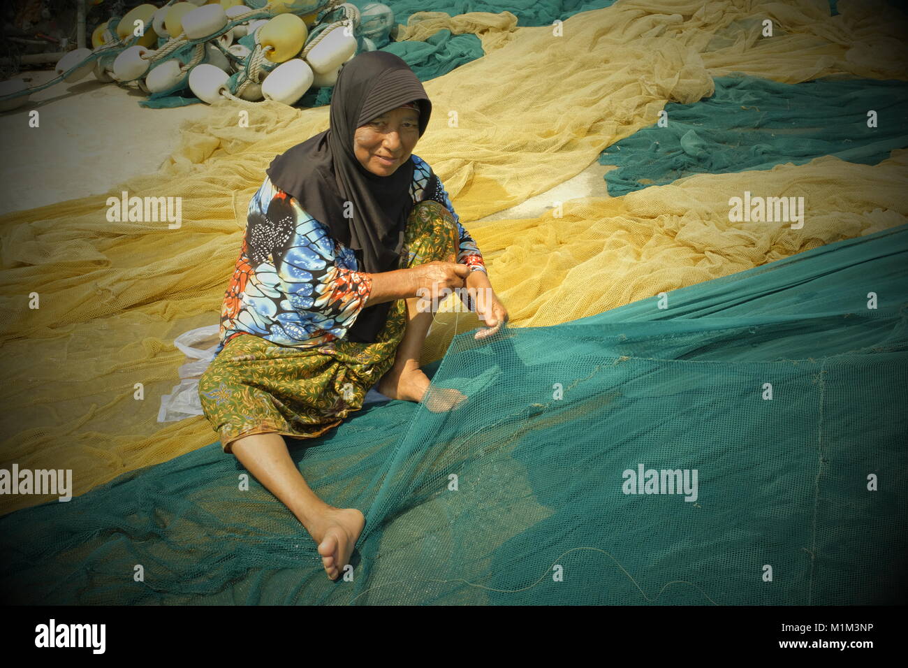 Locali di donne musulmane tessere la rete da pesca a Koh Yao Yai, un isola thailandese nel Mare delle Andamane. 19-Gen-2018 Foto Stock