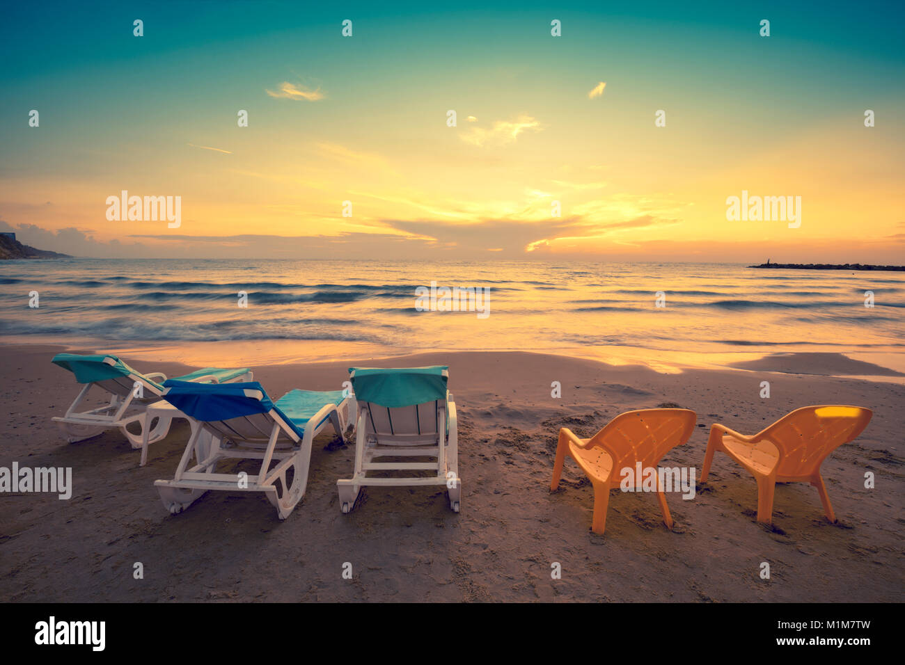 Spiaggia la sera con chaise longue Foto Stock