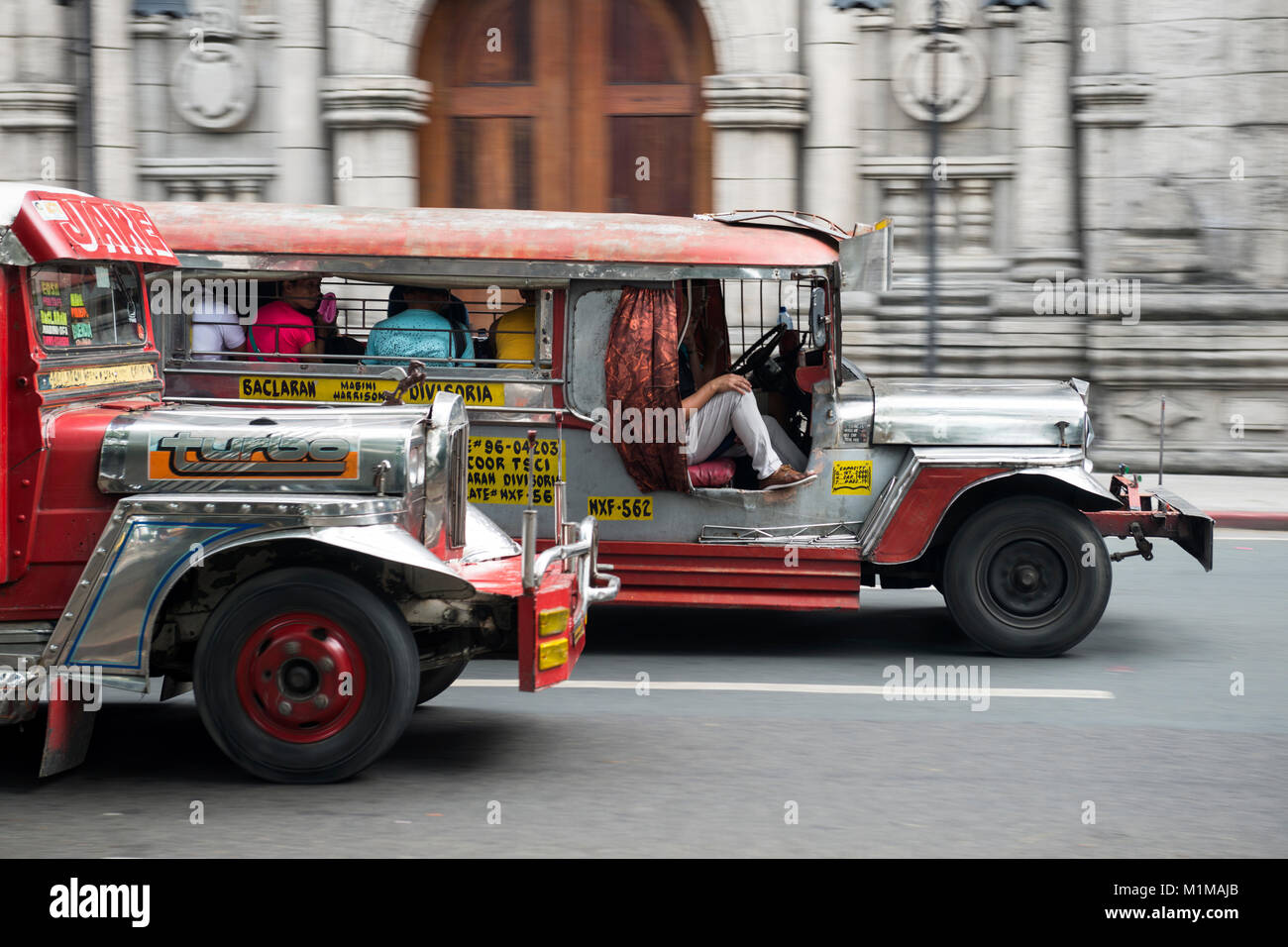 Jeepneys passando malato chiesa cattolica, metropolitana Manila nelle Filippine. Foto Stock