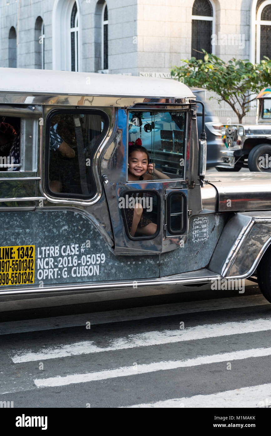 Ragazza giovane guardando al di fuori di un jeepney, Intramuros, Manila, Filippine Foto Stock