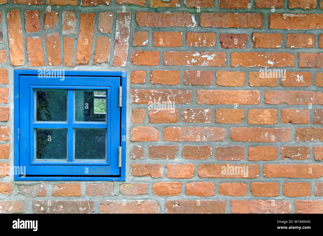 Una finestra blu in un vecchio mattone Foto Stock