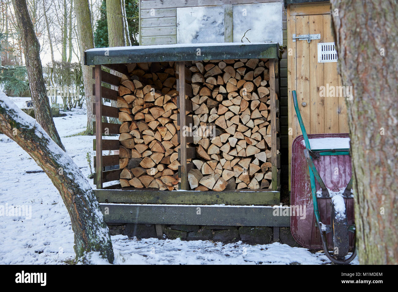 Il carburante invernale log memorizzati in presenza di neve che circonda. Nidderdale Foto Stock