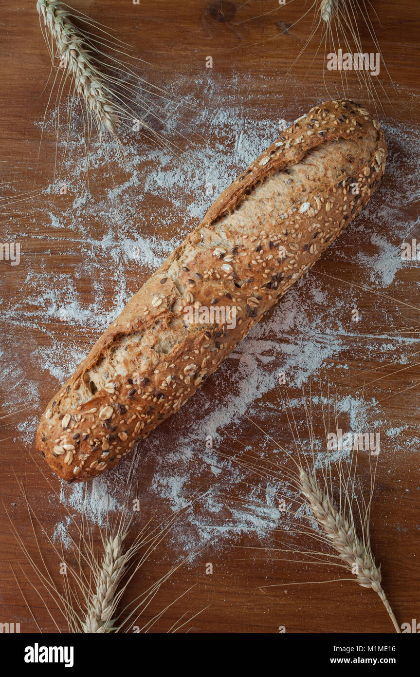 Pane fresco con diversi semi sul rustico sfondo di legno Foto Stock