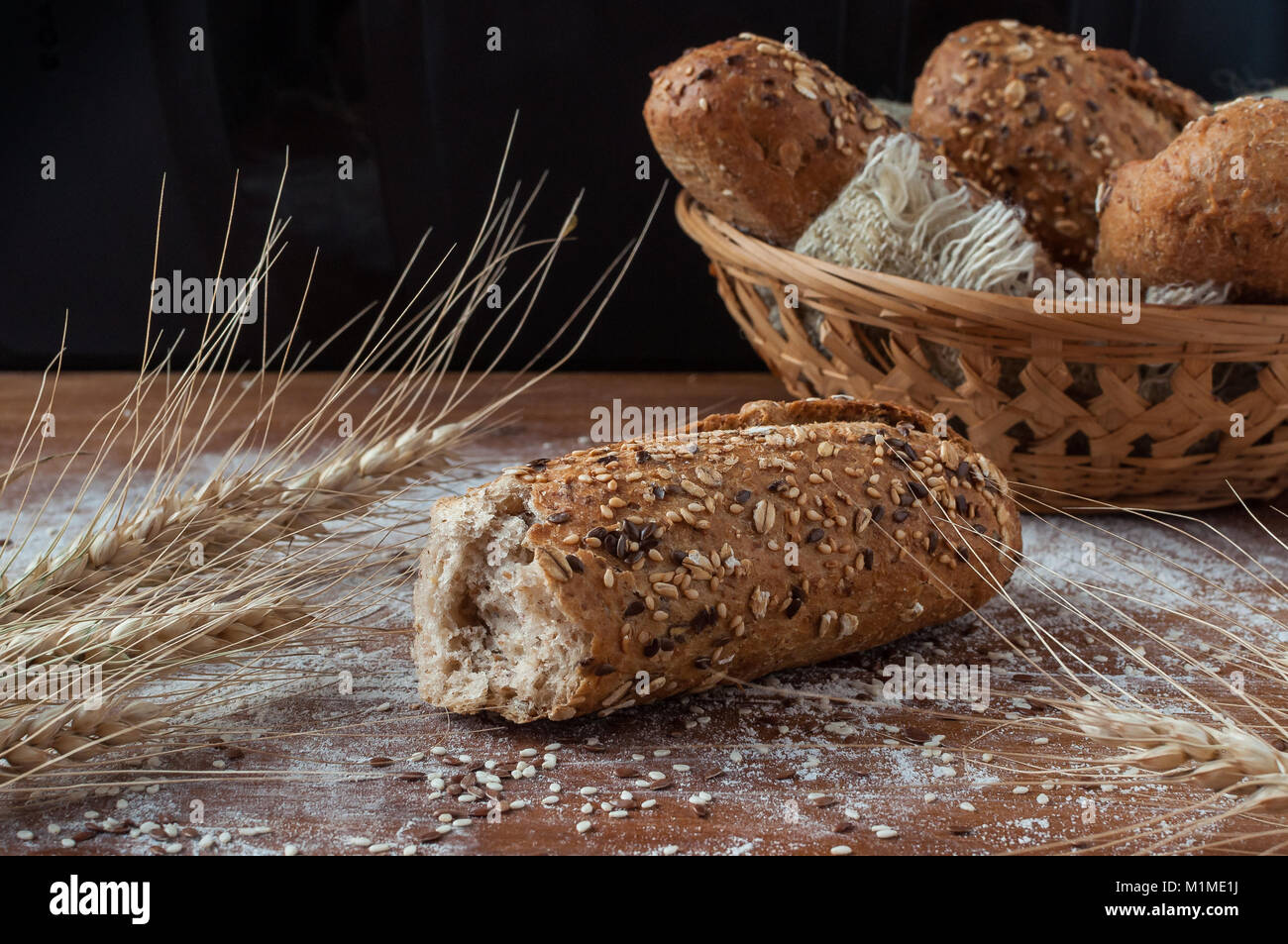 Pane fresco con diversi semi sul rustico sfondo di legno Foto Stock