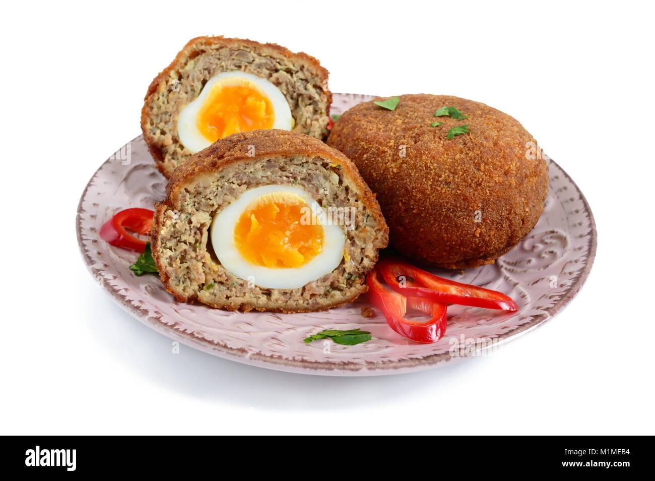Succosa cotoletta di carne tritata farcite uova sode o su una piastra di ceramica isolata su uno sfondo bianco. Foto Stock