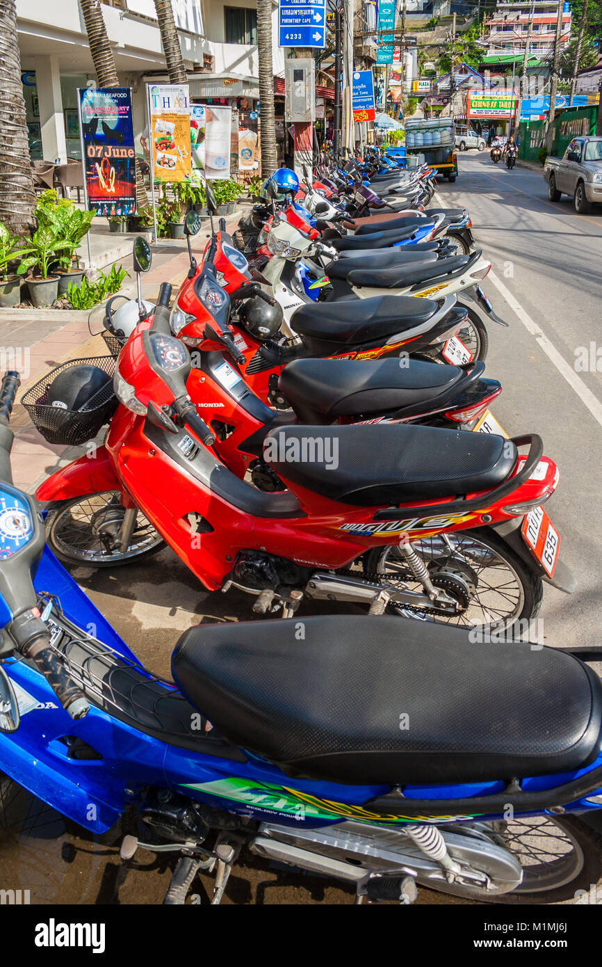 Una tipica scena nel sud-est asiatico. Un sacco di moto parcheggio molto vicini gli uni agli altri in fila sul bordo della strada di Soi Pakbang, accanto alla spiaggia di Kata. Foto Stock