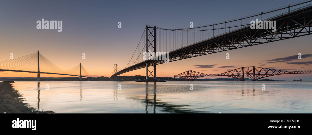 Forth Road e i ponti ferroviari e il ponte di Queensferry Crossing al tramonto, Fife, Scozia, Regno Unito Foto Stock