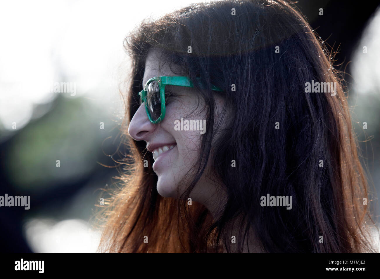 Ritratto di una donna in piedi all'aperto indossando occhiali da sole Foto Stock