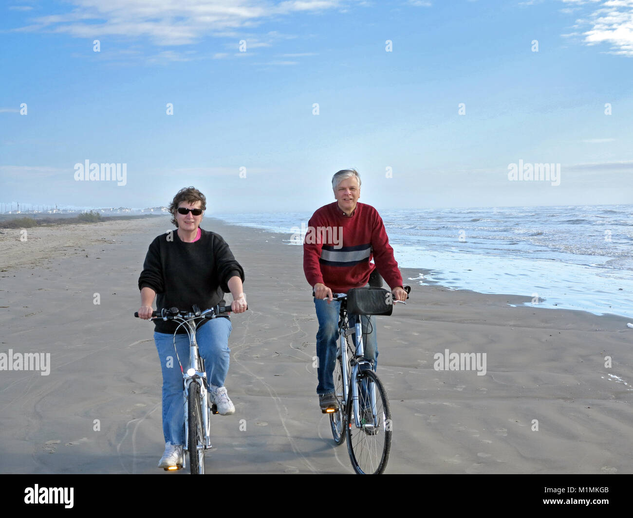 Coppia attiva in bicicletta sulla Mustang Island, Corpus Christi, Texas, Stati Uniti d'America Foto Stock