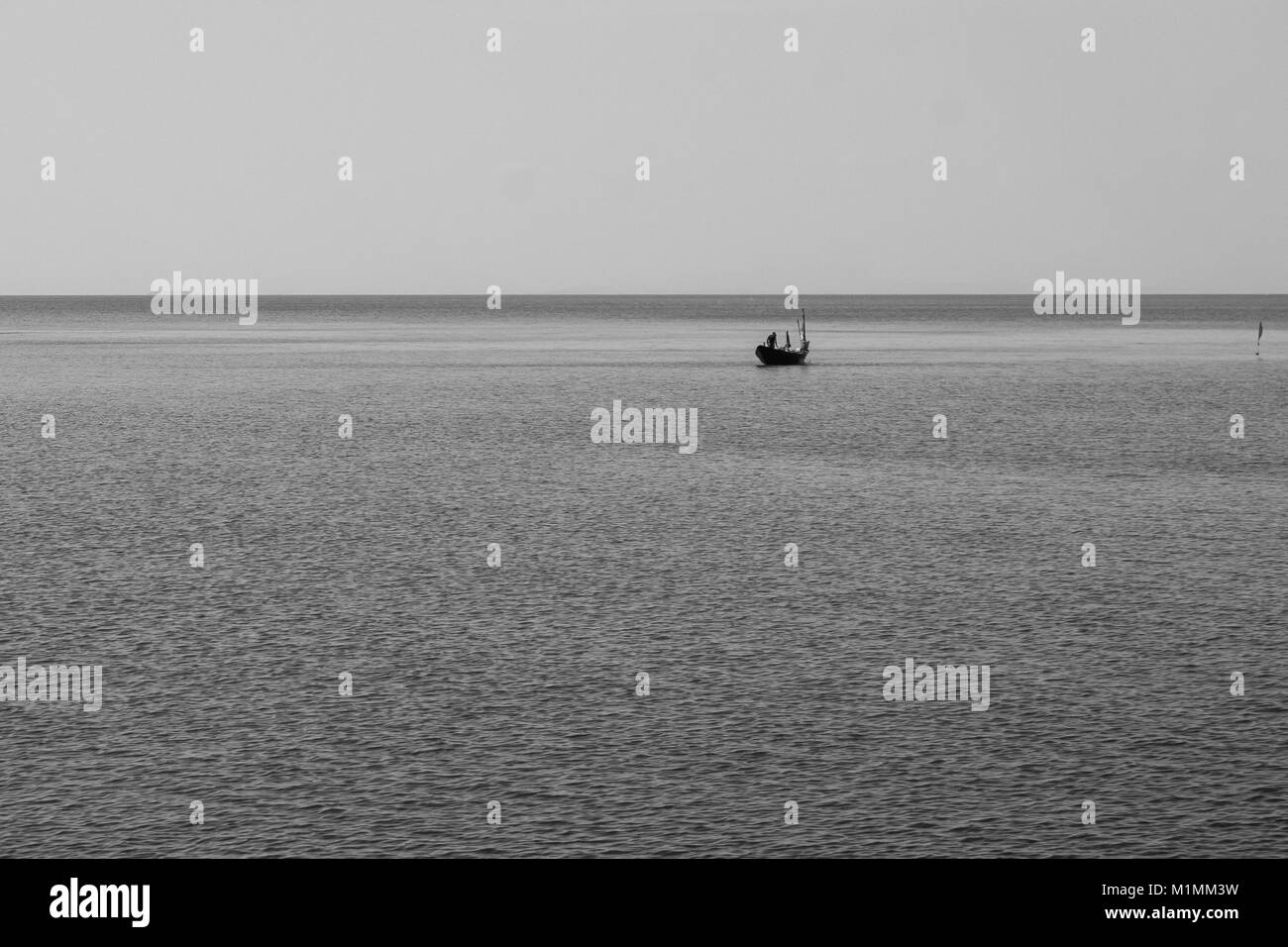 Abstract in bianco e nero e il minimo Concetto di immagine di lonely barca da pesca galleggiante sul mare. Foto Stock