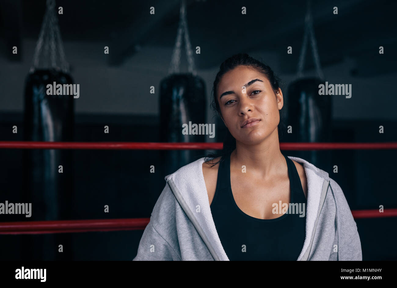 Close up di un boxer femmina in piedi all'interno di un anello di inscatolamento. Boxer di formazione presso un studio di inscatolamento. Foto Stock