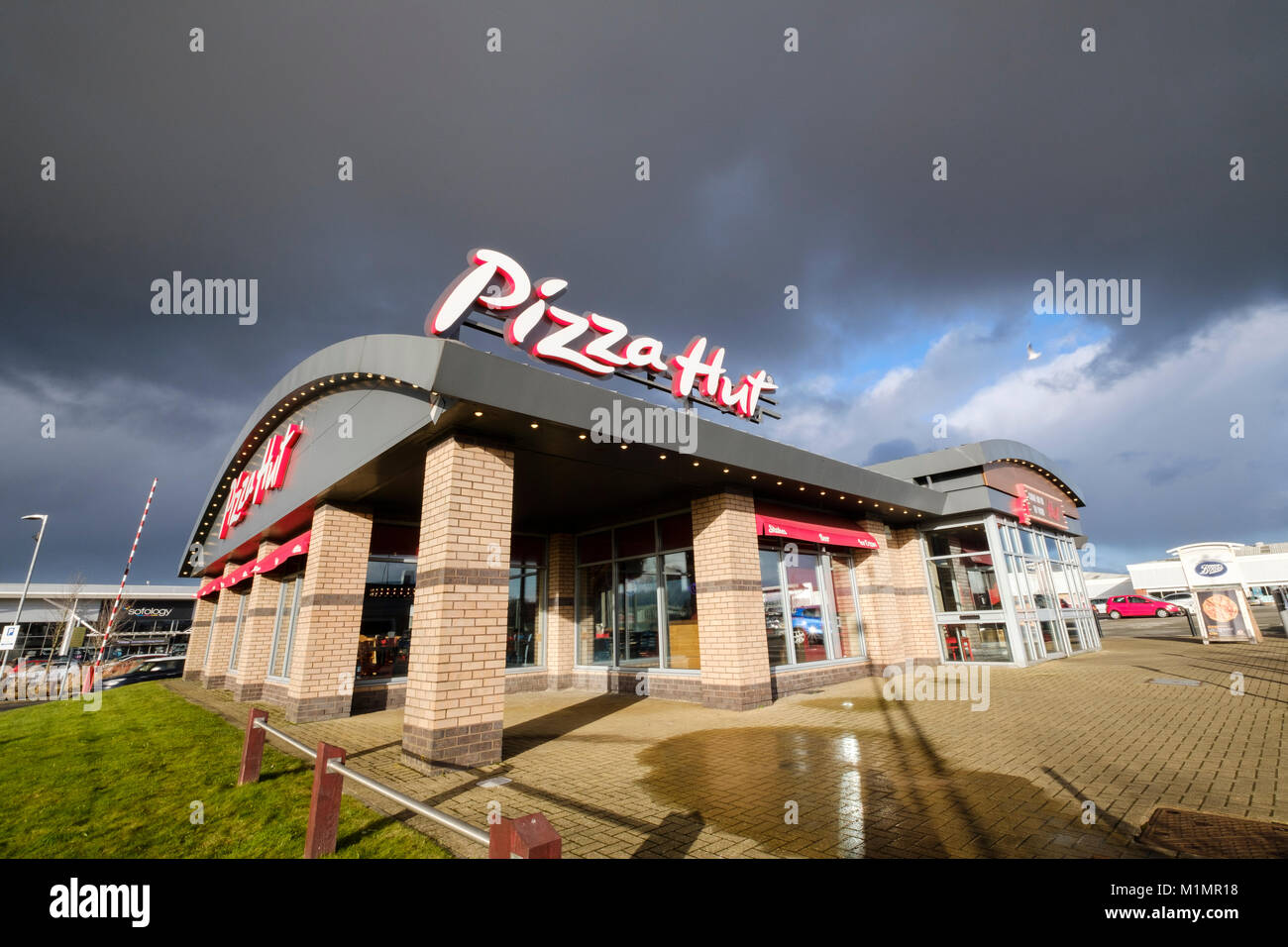 Pizza Hut ristorante nella luce del sole con le nuvole scure dietro. Foto Stock
