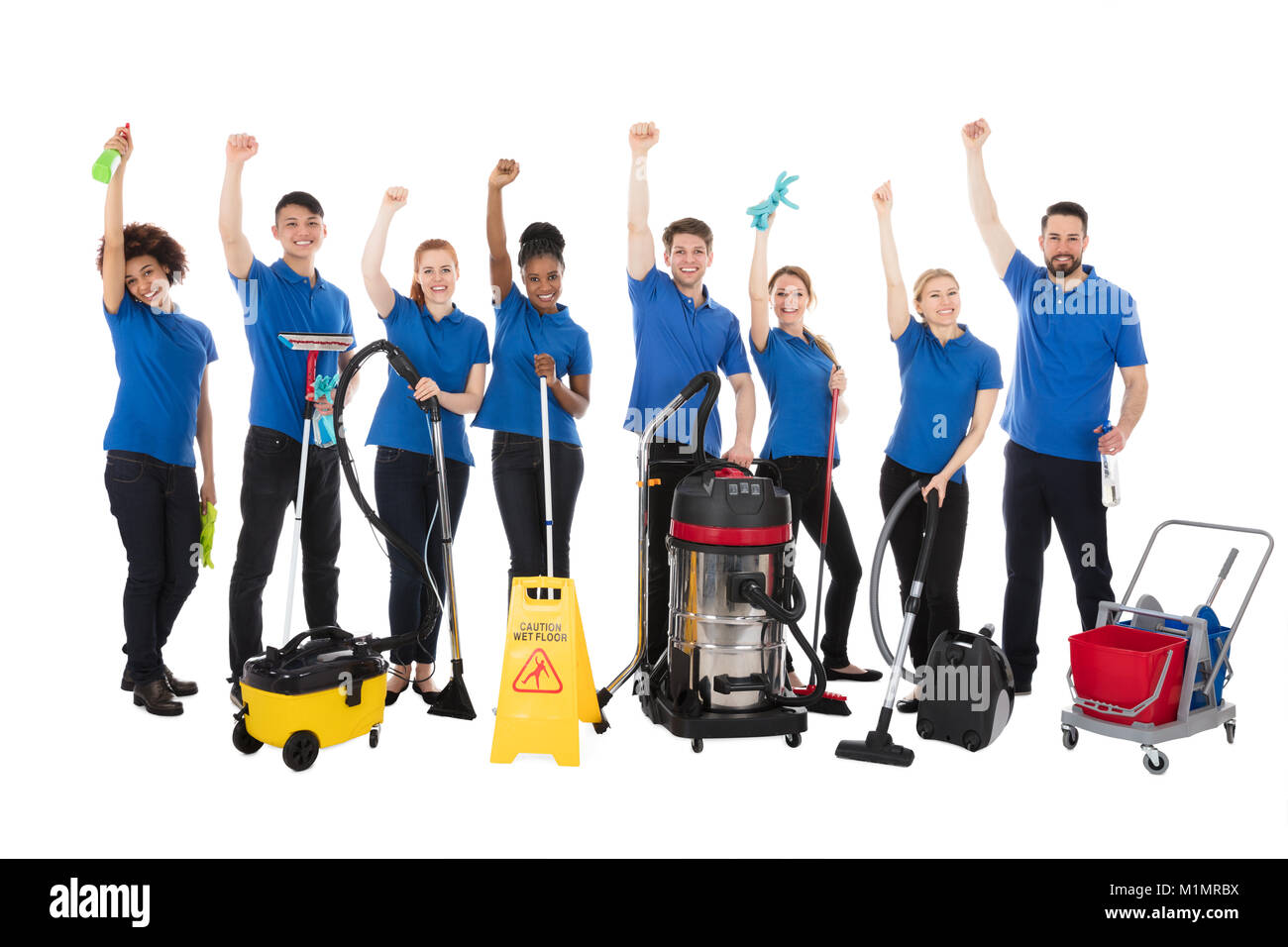 Gruppo di Felice portieri con le apparecchiature di pulizia sollevando i bracci Foto Stock