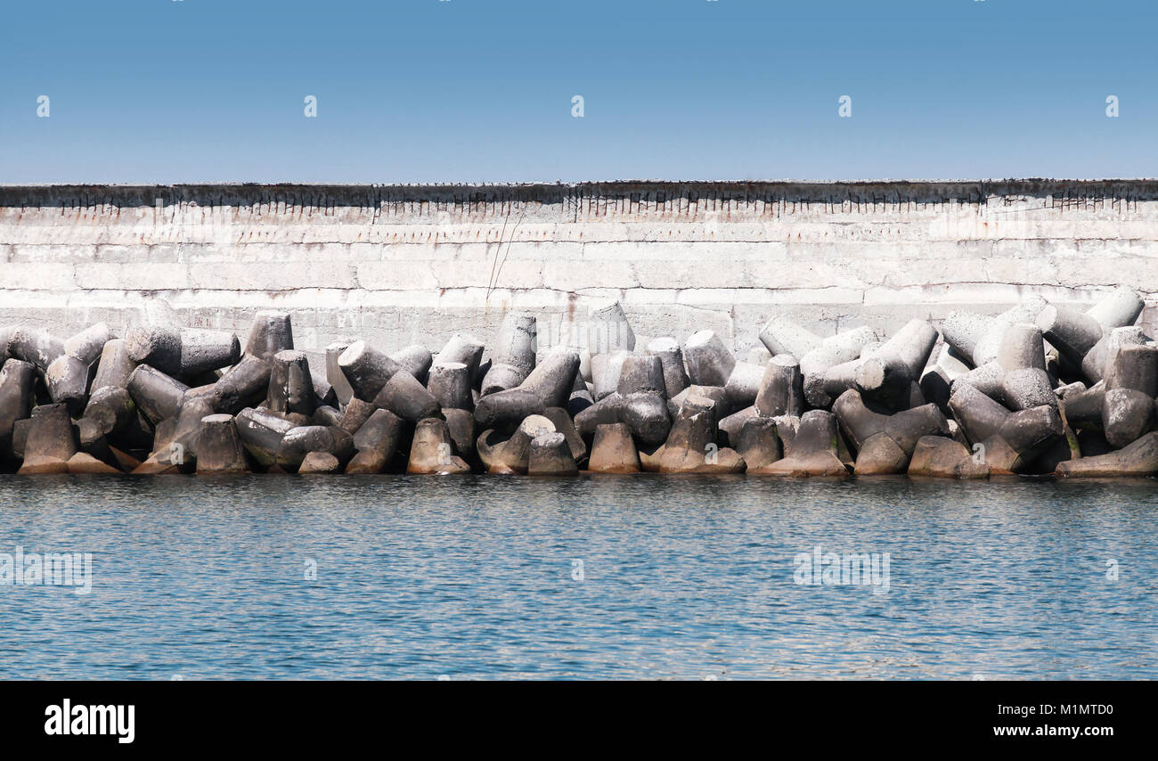 Struttura di frangionde con il muro di calcestruzzo ruvido blocchi, struttura interna per la protezione porta Foto Stock