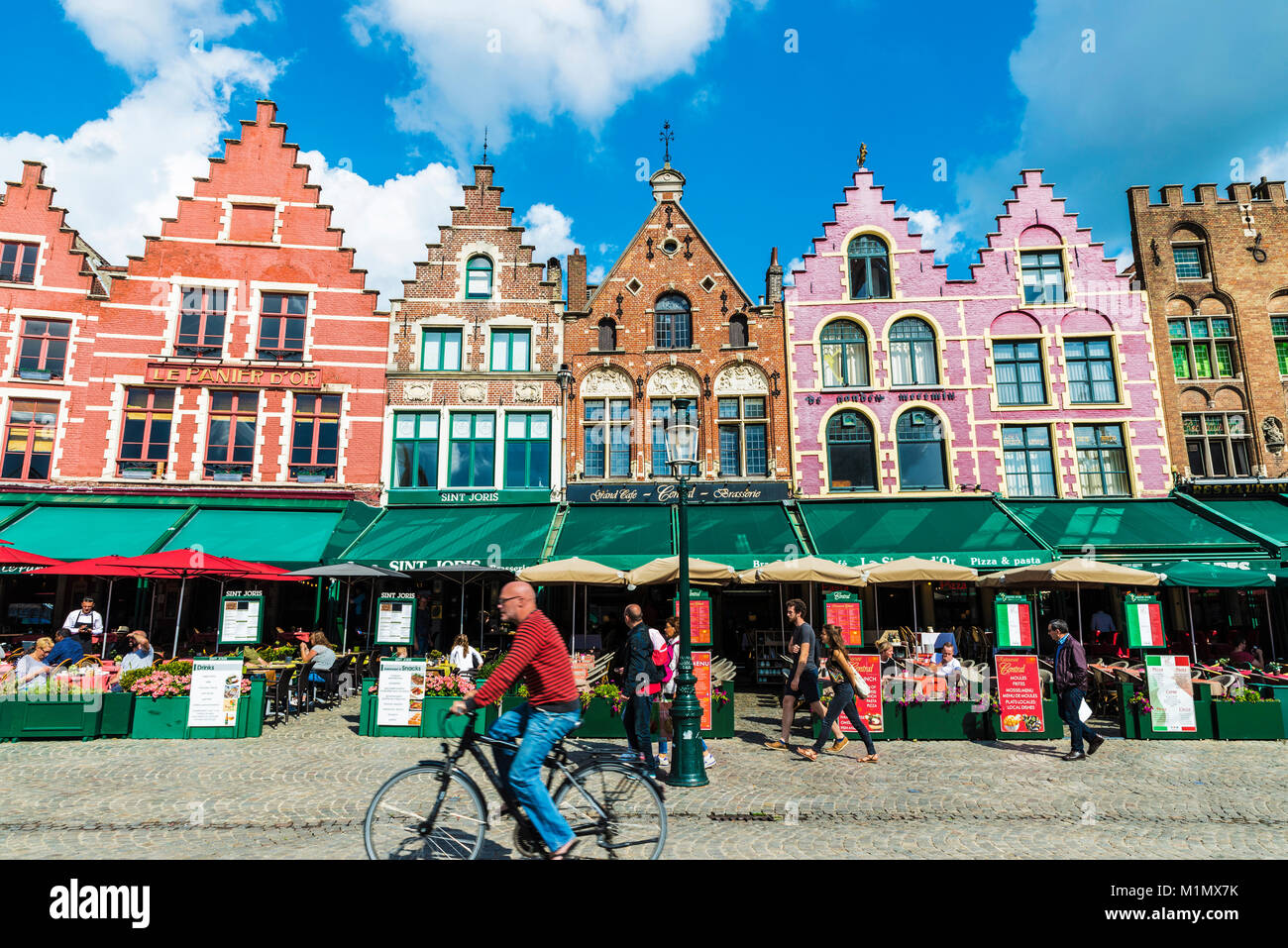 Bruges, Belgio - 31 agosto 2017: il vecchio colorate case tradizionali con i bar e i ristoranti del Grote Markt ( Piazza del Mercato ) con le persone e con le bici Foto Stock