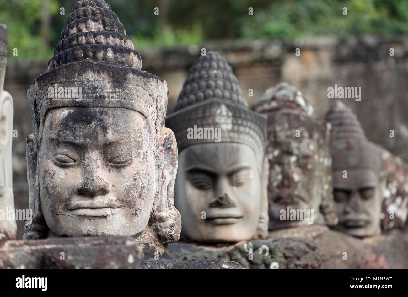 Fila di statue di divinità sul ponte al di fuori del cancello sud di Angkor Thom, Cambogia Foto Stock