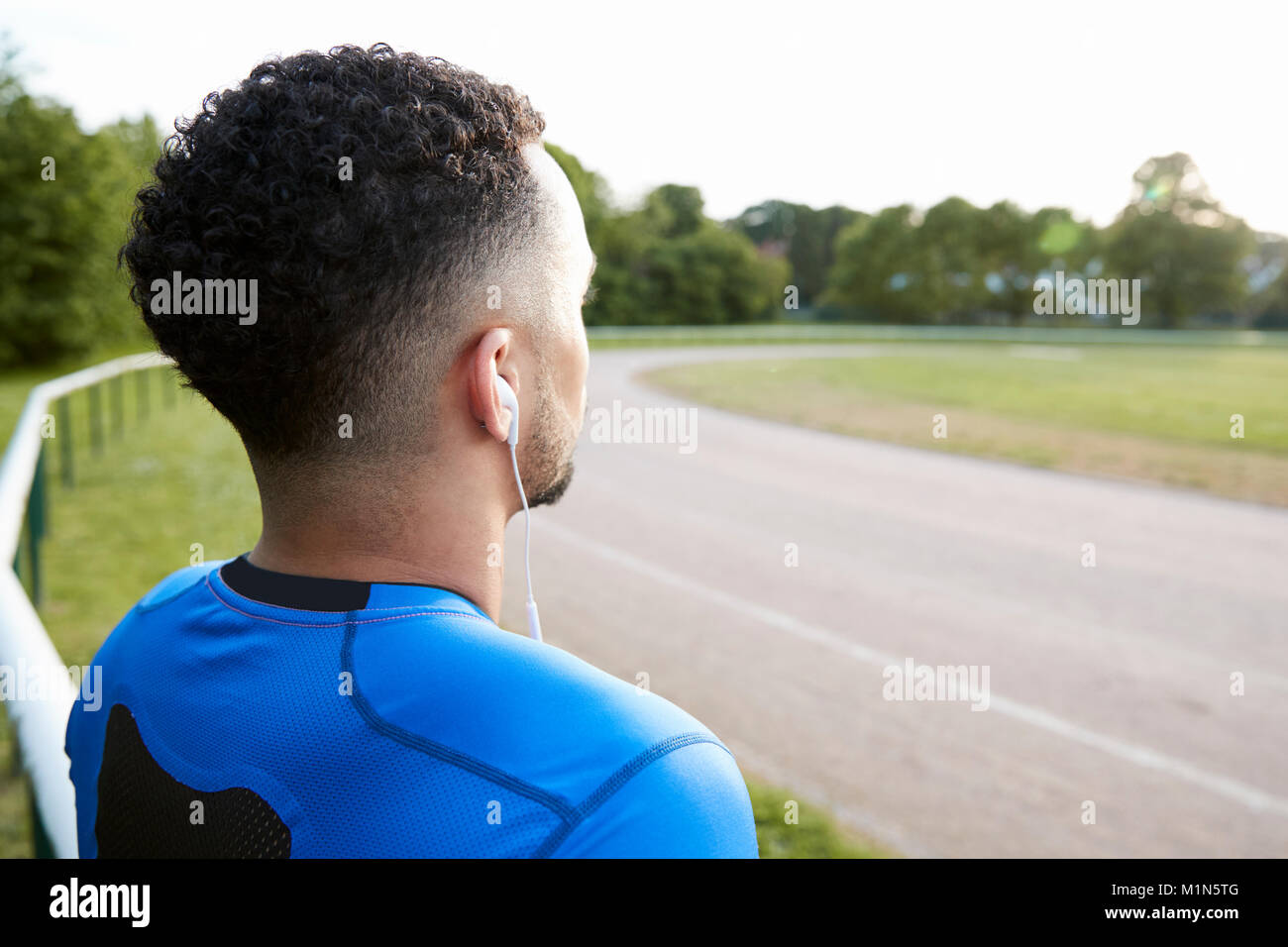 Atleta maschio al via lo sguardo lontano, vicino, vista posteriore Foto Stock