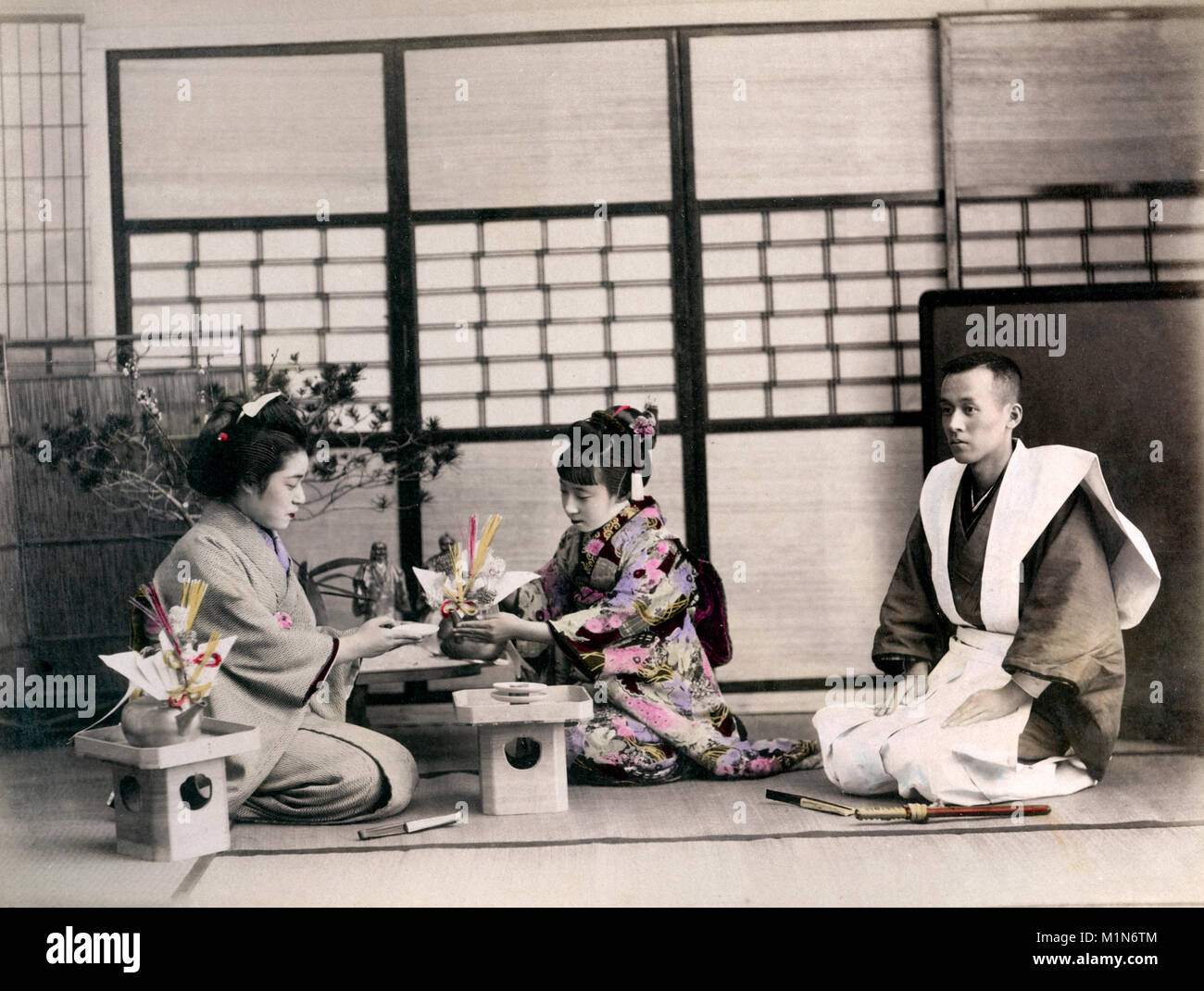 Geishe rendendo giocattoli di carta origami, Giappone, c.1880s Foto Stock