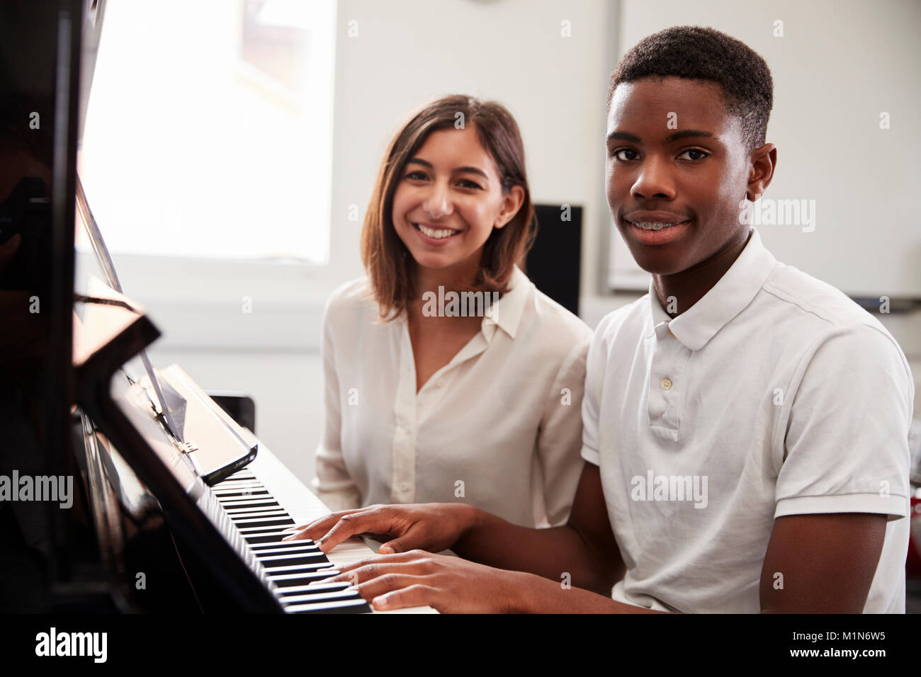 Ritratto di allievo con insegnante suonare il pianoforte nella lezione di musica Foto Stock