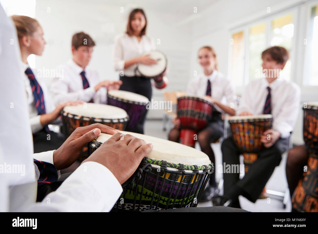 Teenage gli studenti che studiano le percussioni nella classe di musica Foto Stock