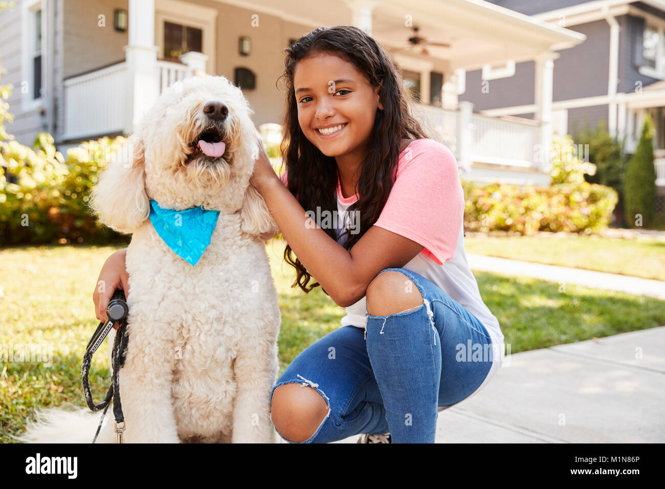 Ritratto di ragazza con cane sulla strada suburbana Foto Stock