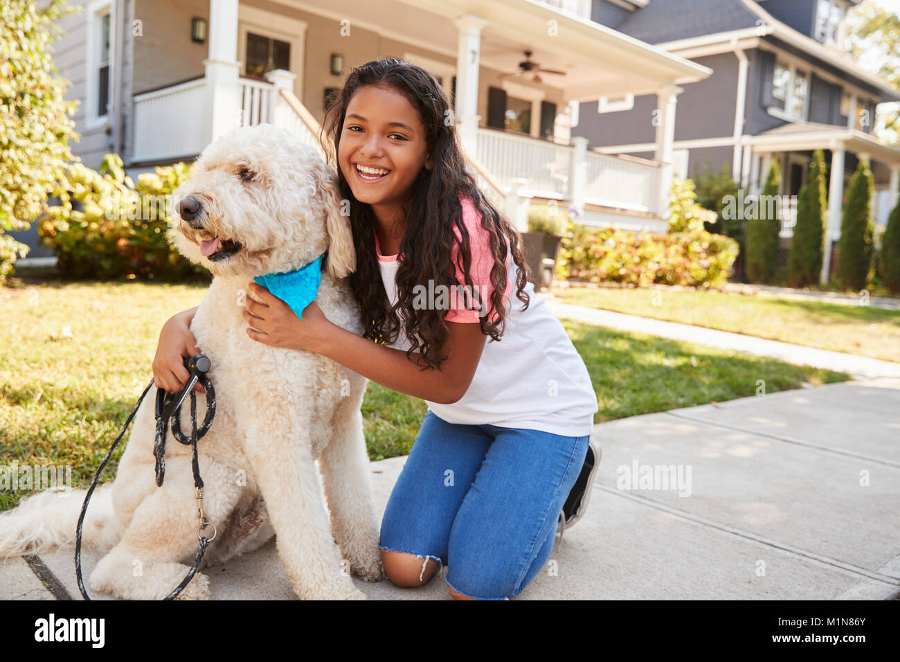 Ritratto di ragazza con cane sulla strada suburbana Foto Stock