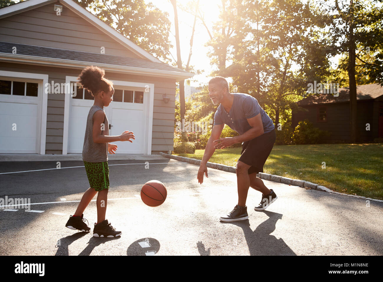 Padre e figlio giocare a basket sulla strada di casa Foto Stock