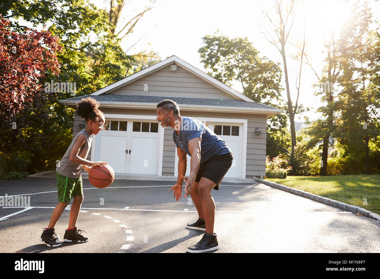Padre e figlio giocare a basket sulla strada di casa Foto Stock