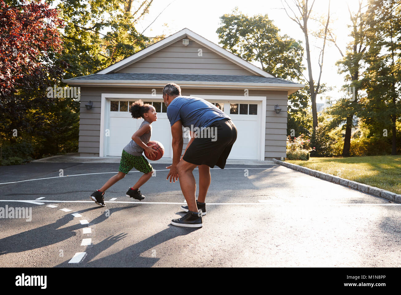 Padre e figlio giocare a basket sulla strada di casa Foto Stock