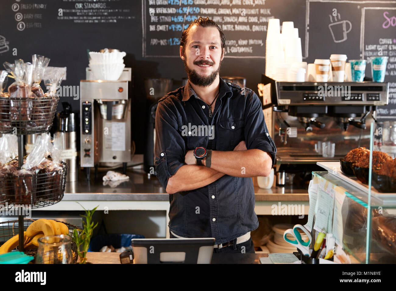 Ritratto di maschio Barista dietro il bancone in Coffee Shop Foto Stock