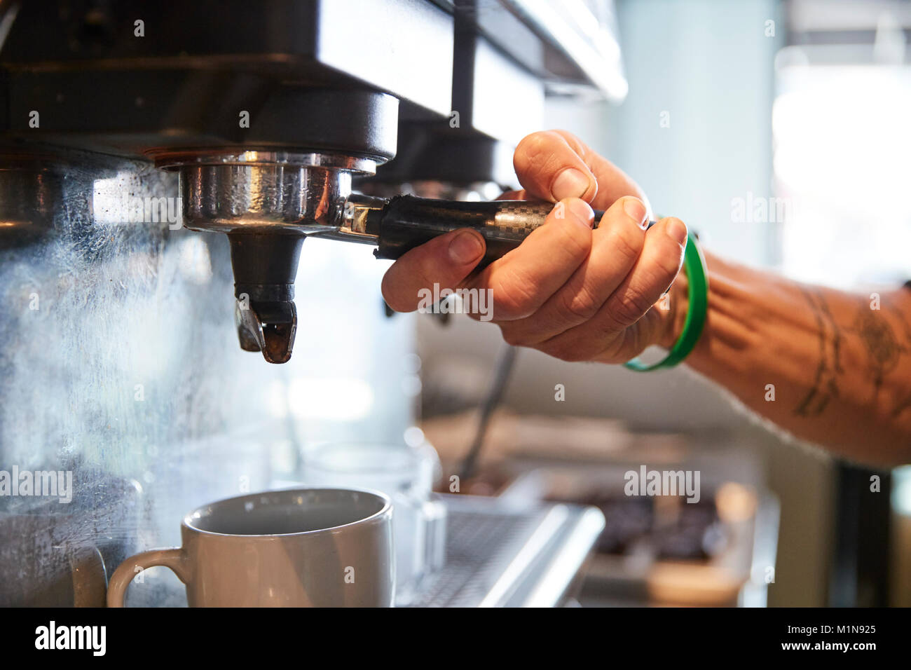 Chiusura del barista maschio con macchina per caffè nella caffetteria Foto Stock