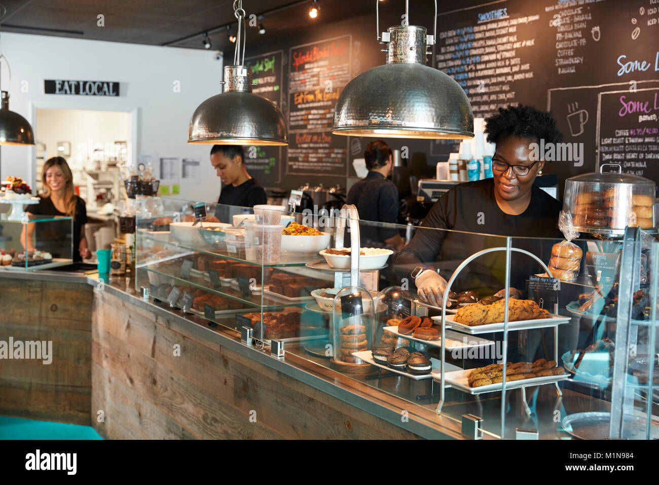 Il personale che lavora dietro il bancone in Busy Coffee Shop Foto Stock