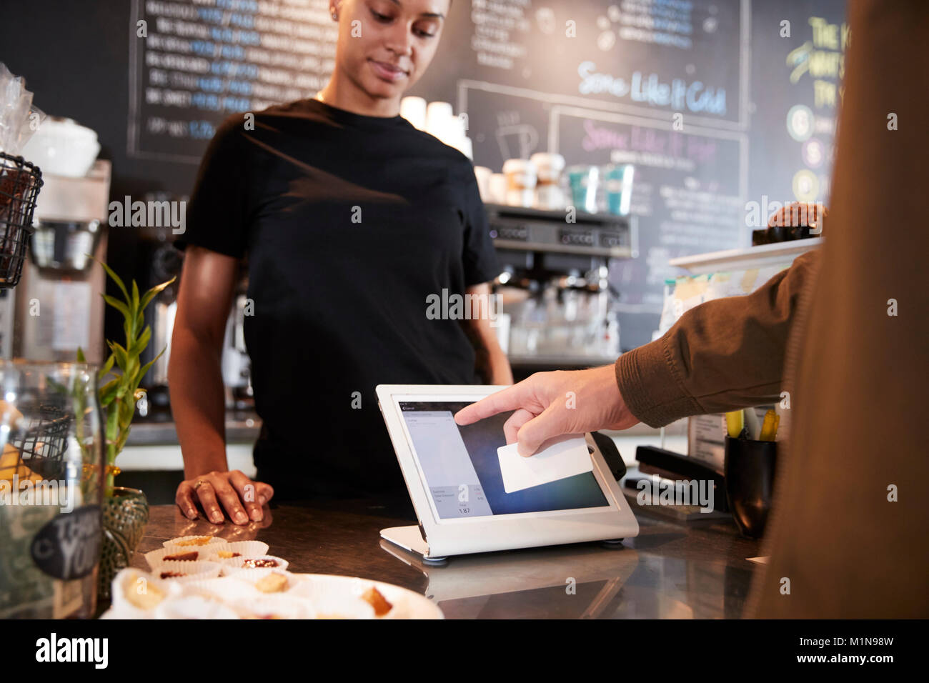 Il cliente di pagare in Coffee Shop utilizzando la carta di credito Foto Stock