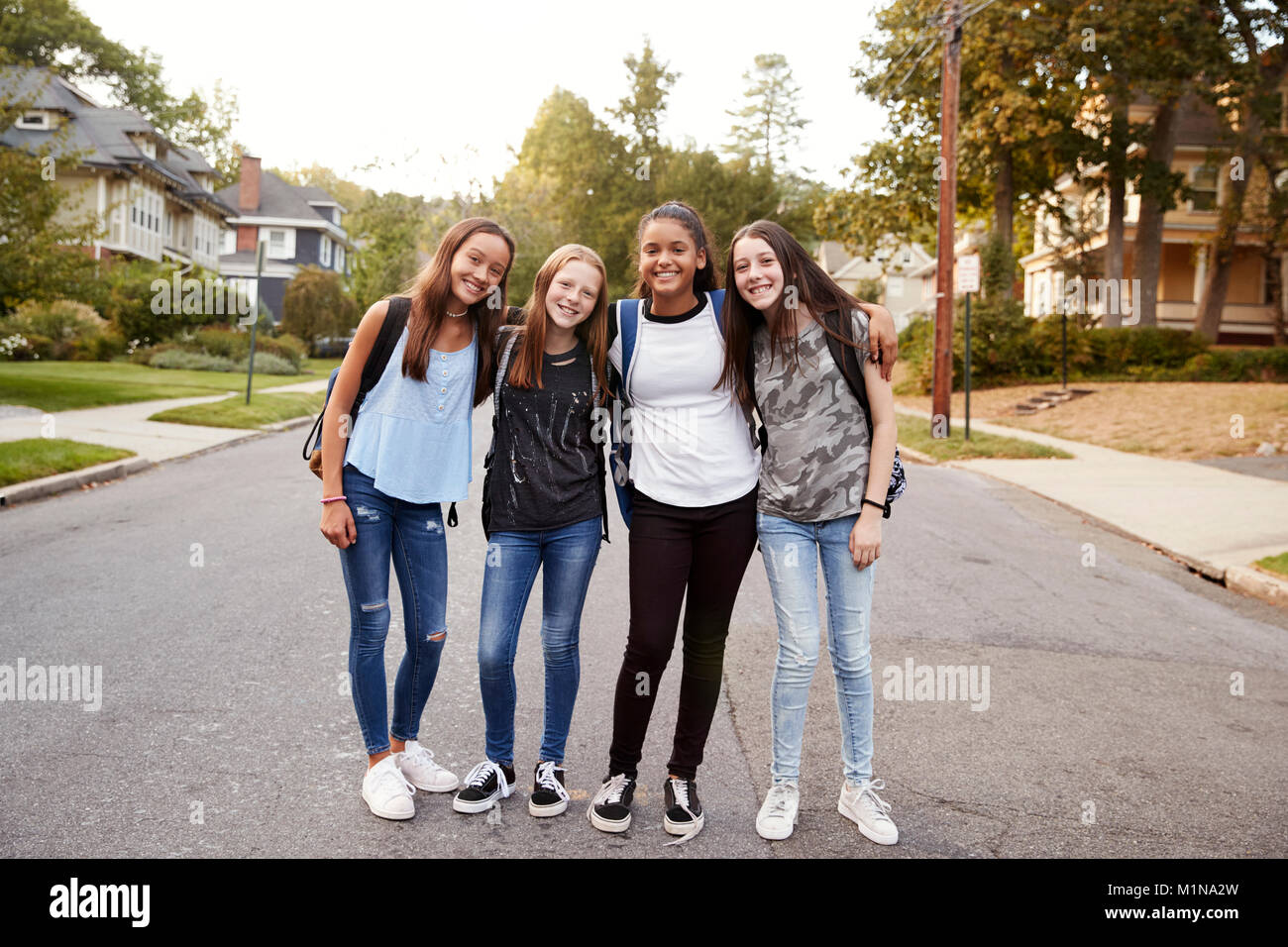 Le ragazze adolescenti sulla strada per la scuola guarda alla telecamera a piena lunghezza Foto Stock