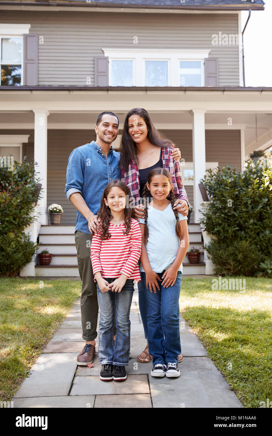 Ritratto di famiglia sorridente in piedi di fronte a loro casa Foto Stock