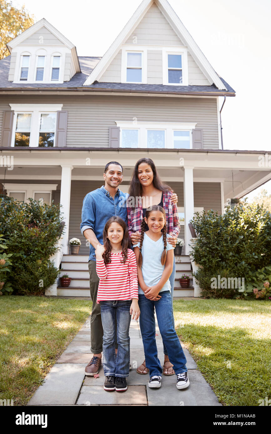 Ritratto di famiglia sorridente in piedi di fronte a loro casa Foto Stock