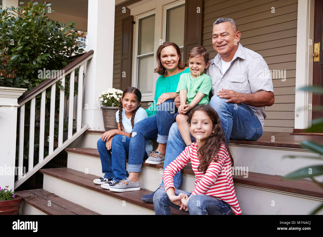 Nonni con i nipoti sedersi sulla scalinata che conduce fino alla Home Foto Stock