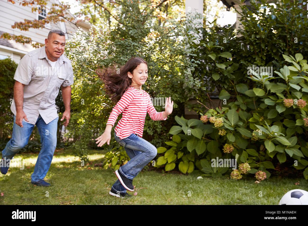 Nonno che giocano a calcio nel giardino con la nipote Foto Stock